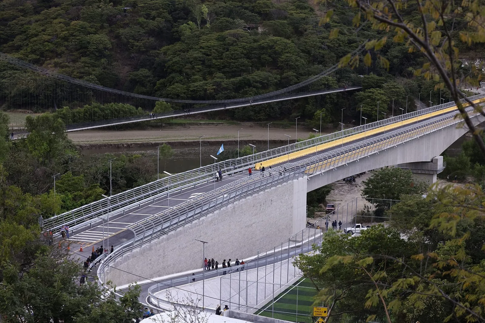 Ladera cubierta de bosque junto a un río con puentes
